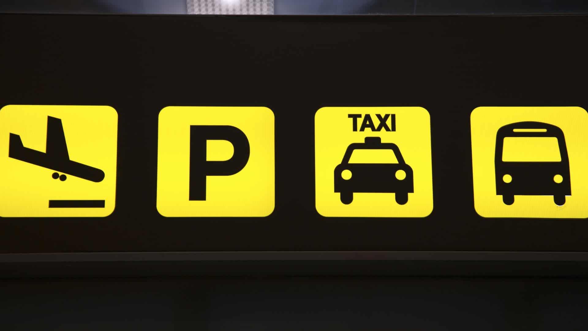 An airport transport sign with yellow icons.
